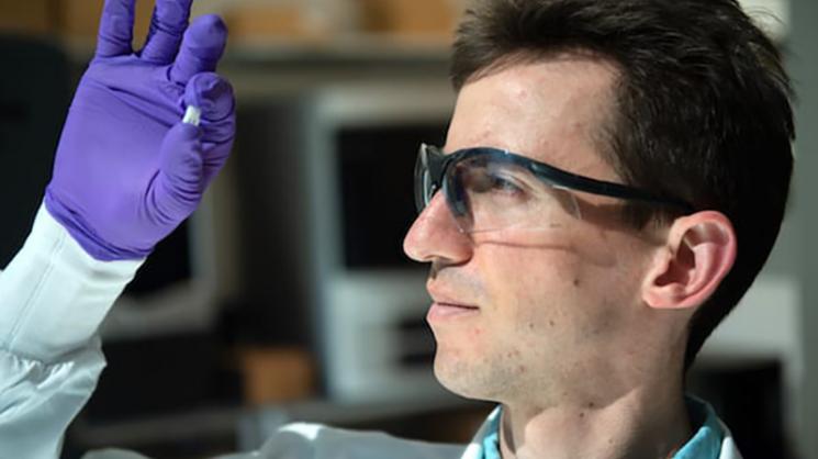 Rice University graduate student Sean Bittner holds a sample of a 3D-printed scaffold that may someday help heal osteochondral injuries of the kind often suffered by athletes.