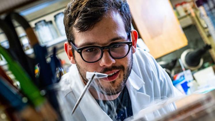 Rice University graduate student Ian Campbell pulls a vial of ferredoxin proteins from cold storage. The iron and sulfur proteins, believed to be present at the start of life on Earth, facilitate the transfer of energy in cells. The Rice experiments showed synthetic biologists may use them to control electron transfer in cells. Photo by Jeff Fitlow